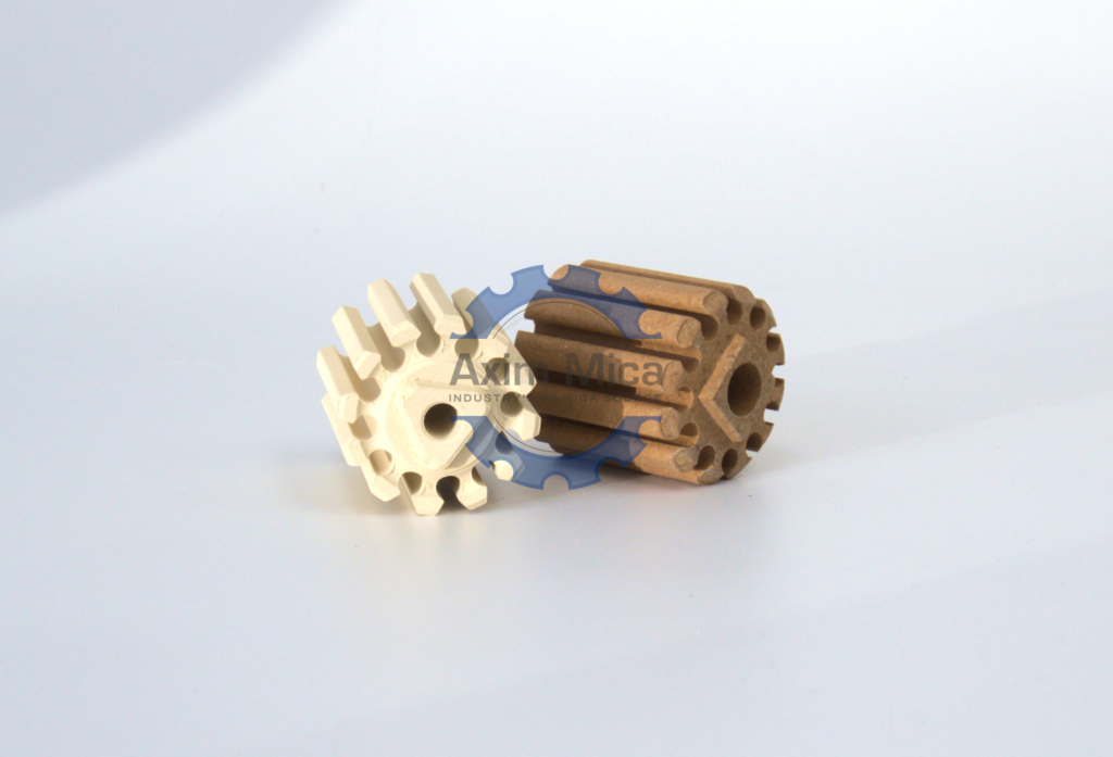 Close-up of two gears crafted from mica ceramics, positioned on a clean white surface, highlighting their texture.